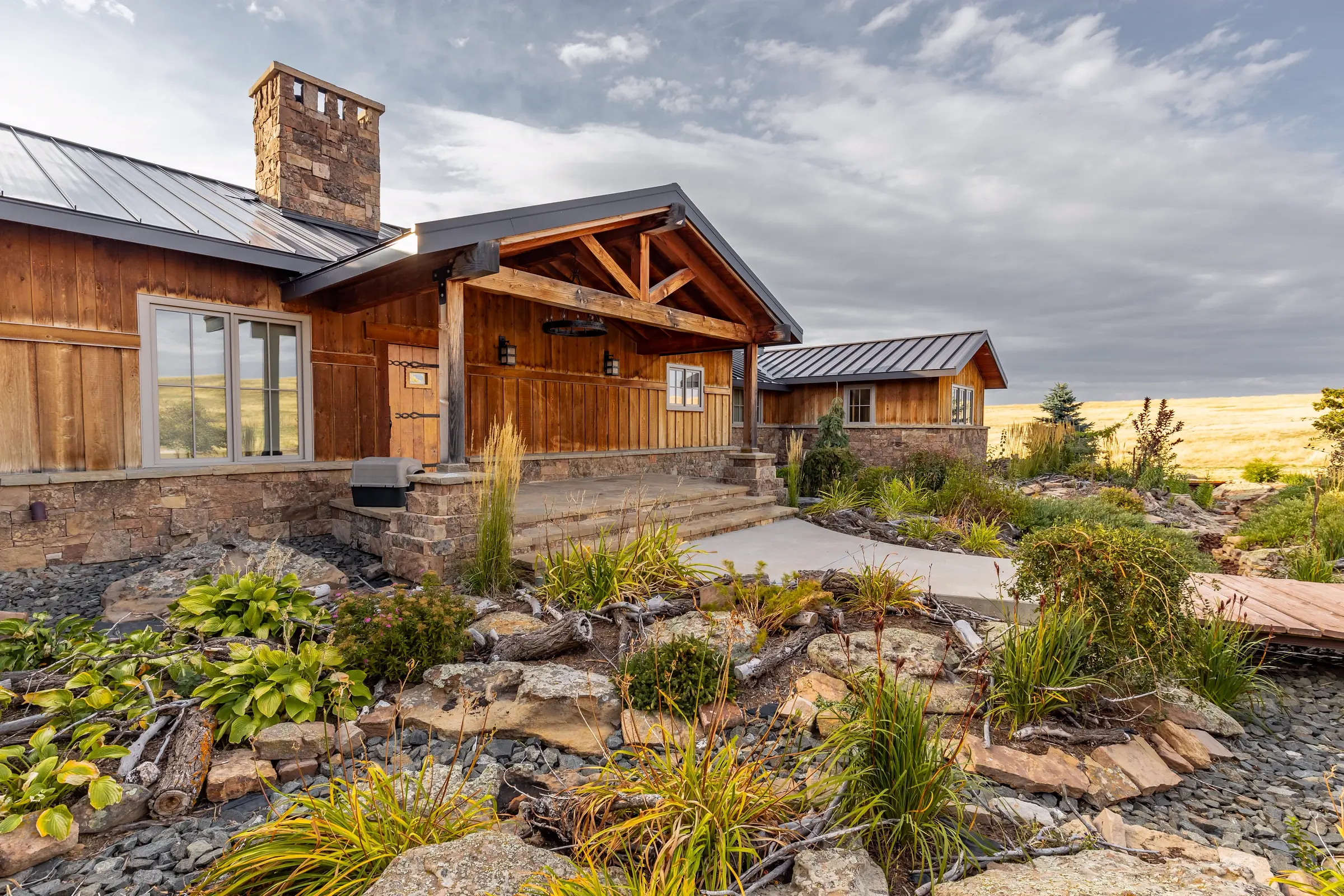 Wood and stone mountain home with a covered porch and landscaped rock garden (illustrative, not an actual listing)